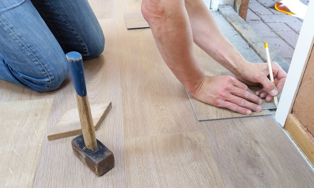 person installing new floorboards